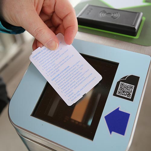 Hand scanning a paper ticket at a fare gate.