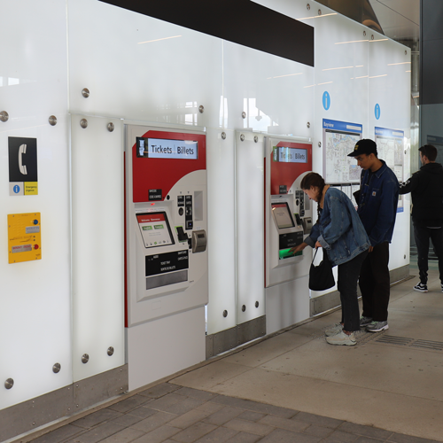 Usagers utilisant une distributrice de billets à la station Bayview.