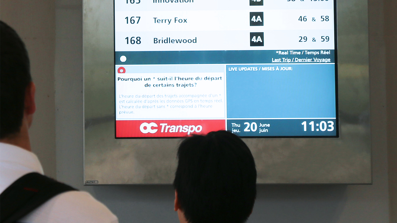 Un usager vérifie l'écran d'information sur les transports en commun